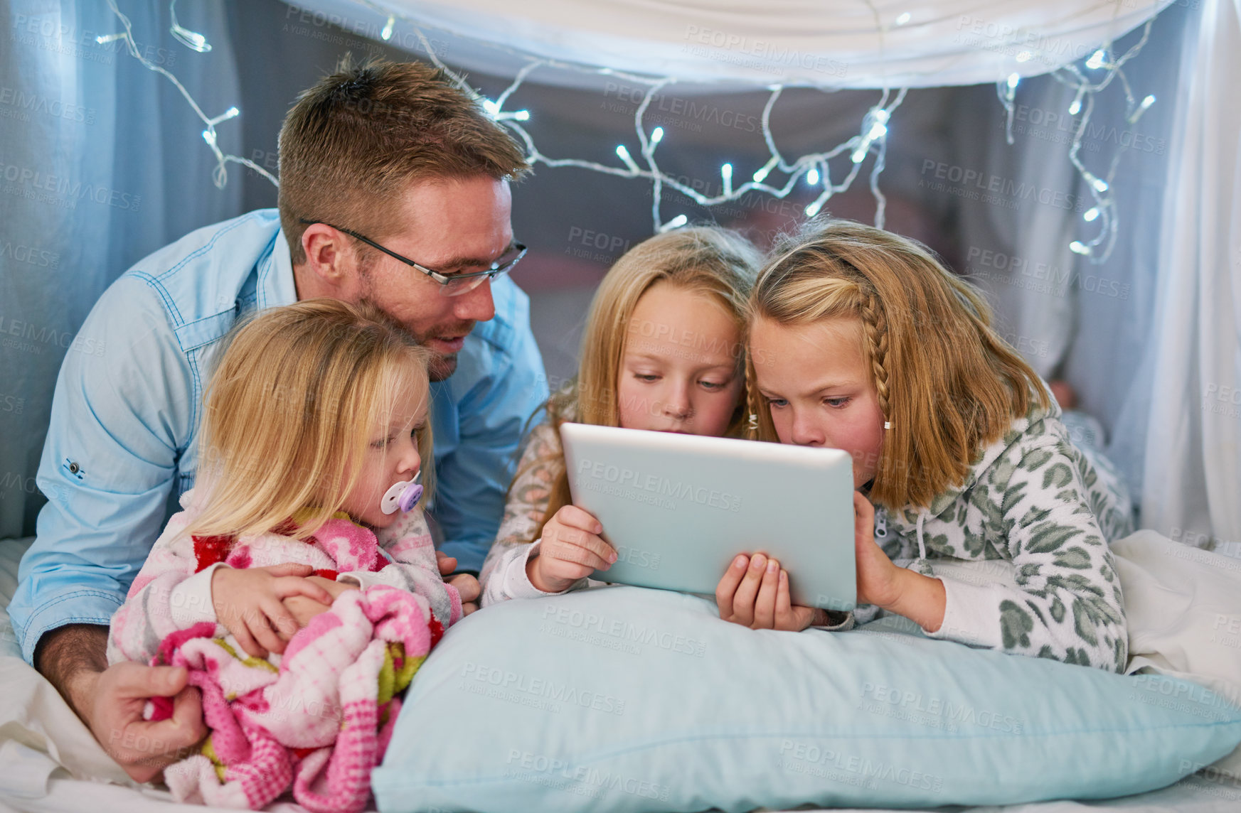 Buy stock photo Happy, family and tablet for streaming tv, watching movies or dad telling story before bedtime. Sisters or friends and touchscreen for entertainment with film or social media in blanket fort at home