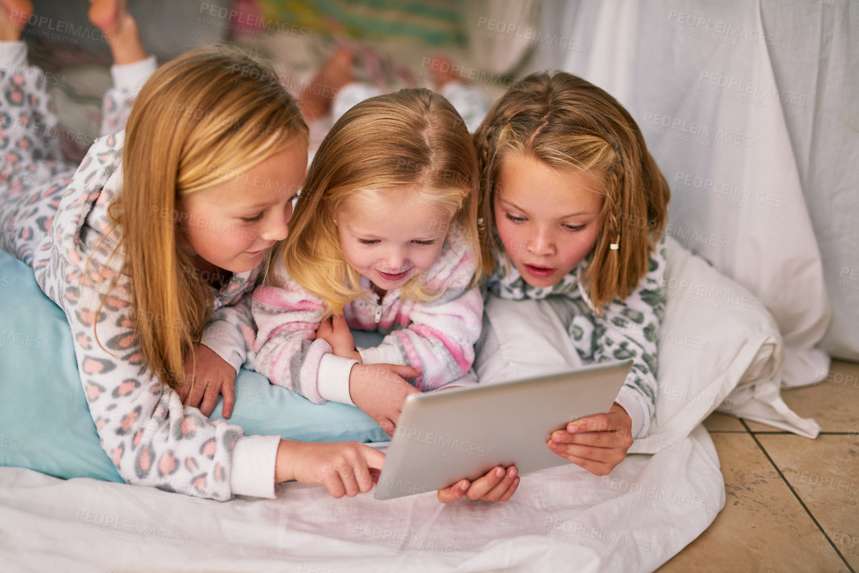 Buy stock photo Girl, relax and kids with tablet in bedroom for online movie, streaming and watching cartoon show. Happy, sisters and smile with technology at home for bedtime, entertainment and bonding together