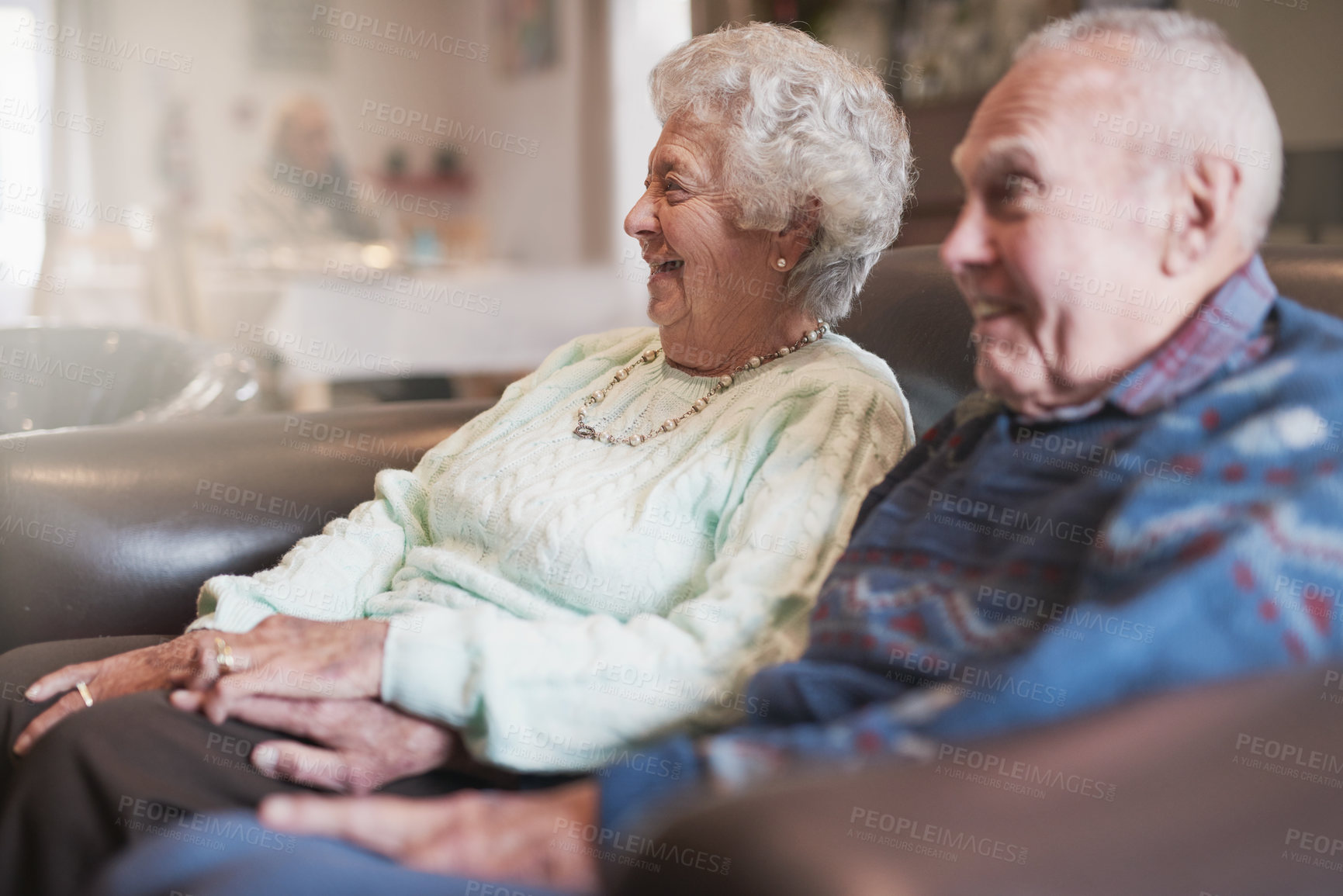 Buy stock photo Laugh, watching tv and senior couple in living room for show, movie or film on sofa in home to relax. Elderly man, woman and television for funny comedy, holding hands or smile together in retirement