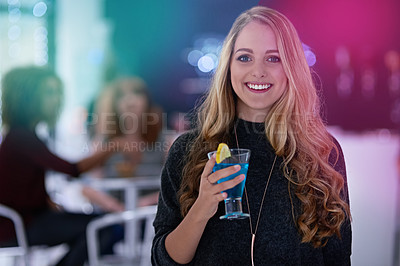 Buy stock photo Portrait of a happy young woman enjoying a cocktail in a nightclub
