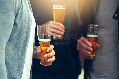 Buy stock photo Cropped shot of a group of unidentifiable friends enjoying a beer together