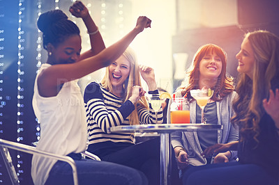 Buy stock photo Shot of a group of friends relaxing with cocktails in a nightclub