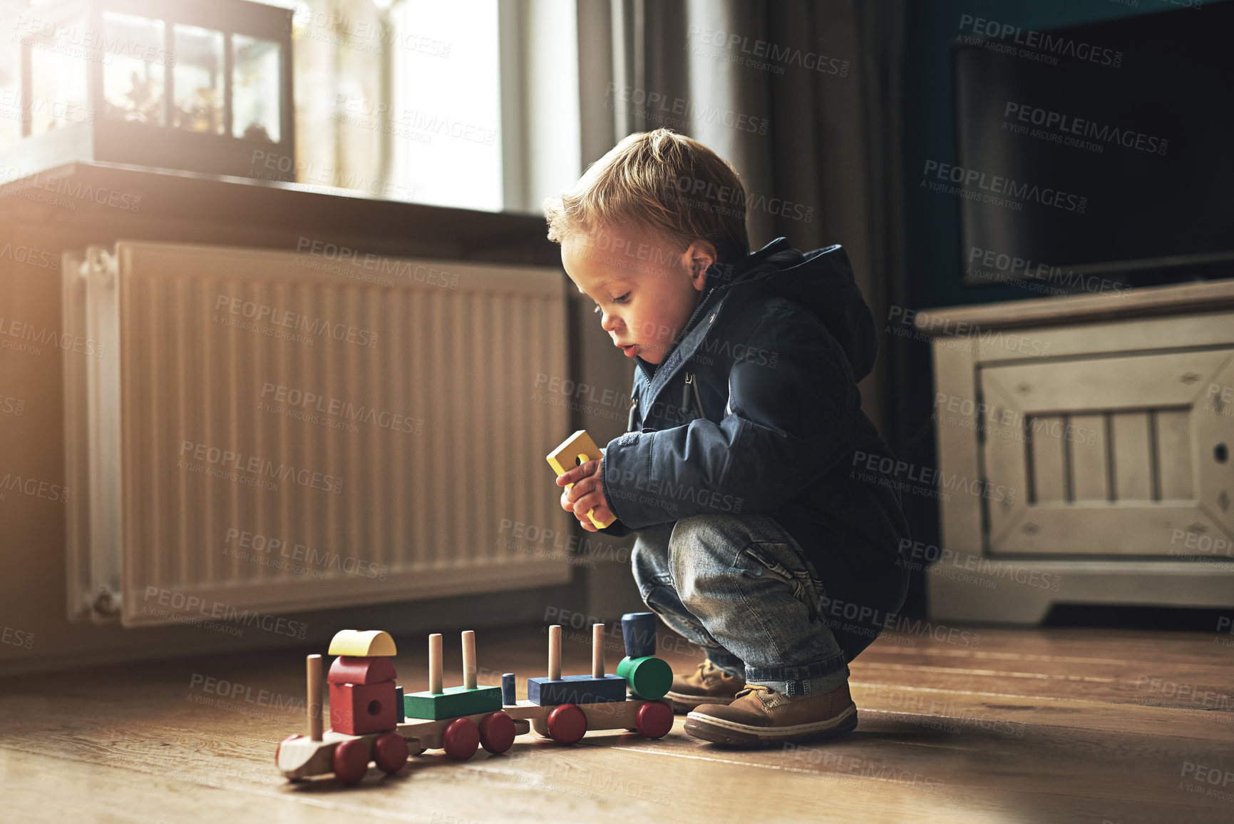 Buy stock photo Cute, playing and boy child with toys for learning, fun and sensory development at home. Sweet, youth and kid or toddler with wooden blocks for building train on floor in living room at house.