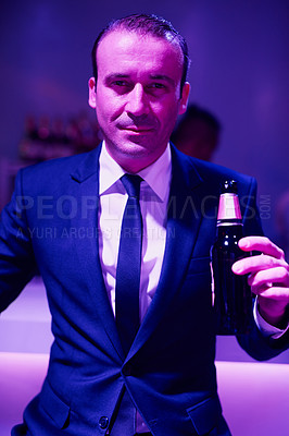 Buy stock photo Portrait of a businessan drinking a beer while sitting in a seedy Thai nightclub
