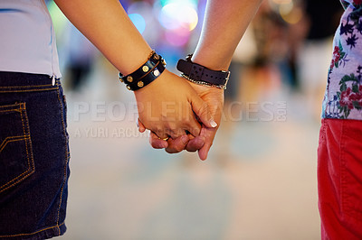 Buy stock photo Cropped shot of a couple holding hands while out in the city