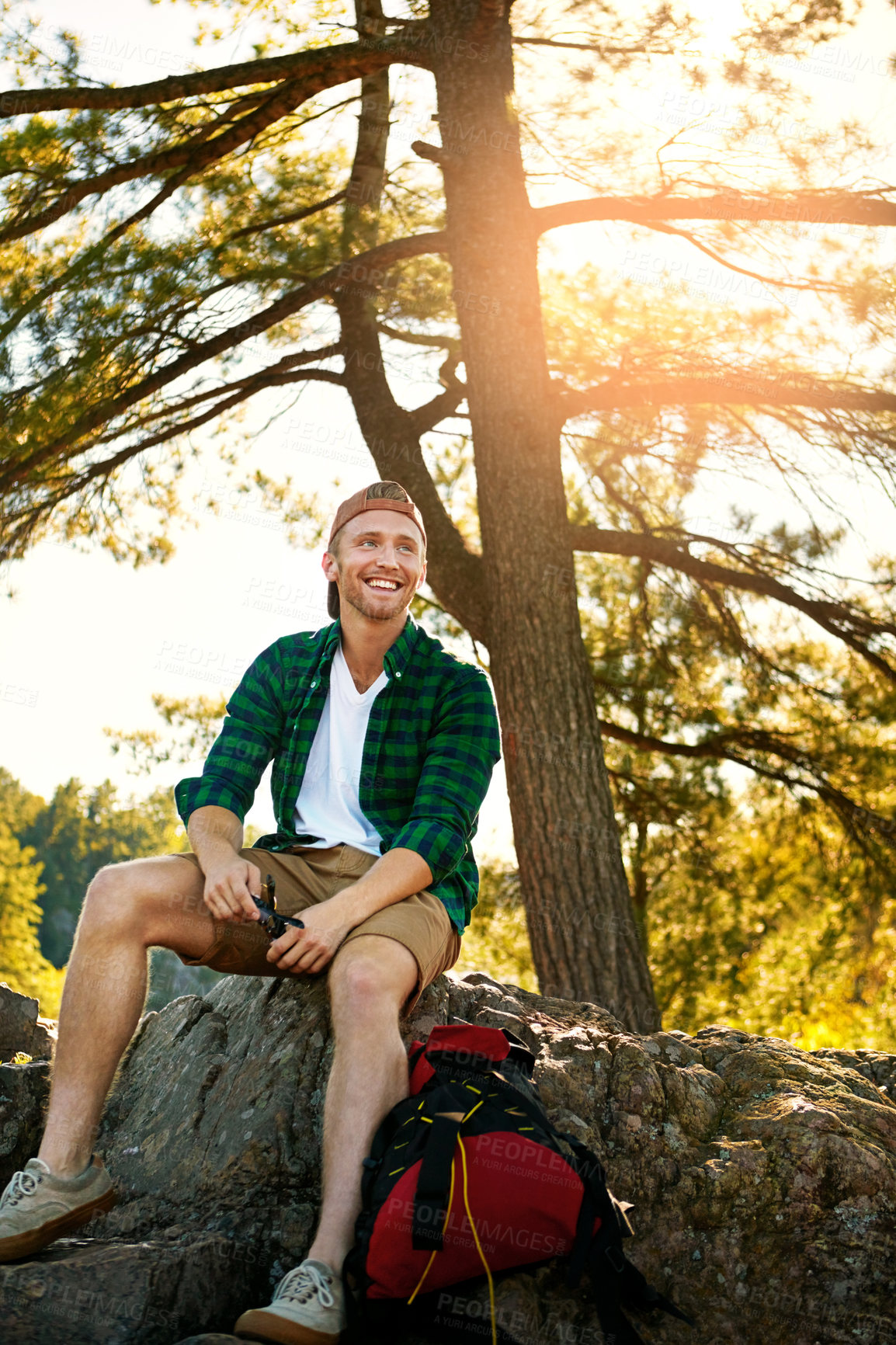 Buy stock photo Shot of a handsome young man hiking while on an overseas trip