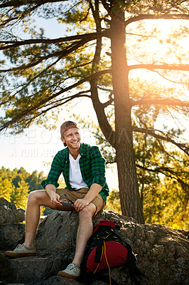 Buy stock photo Shot of a handsome young man hiking while on an overseas trip