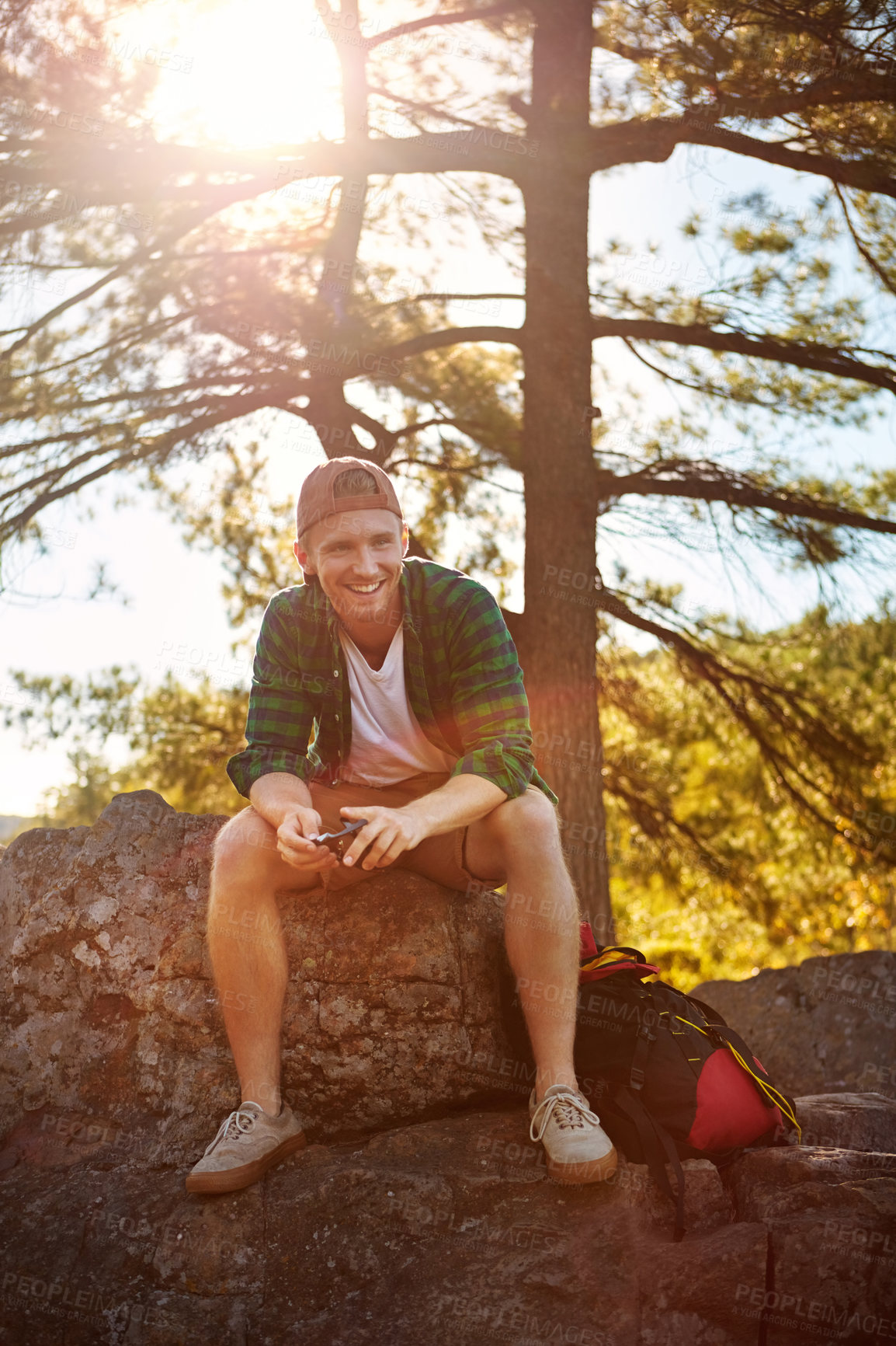 Buy stock photo Shot of a handsome young man hiking while on an overseas trip