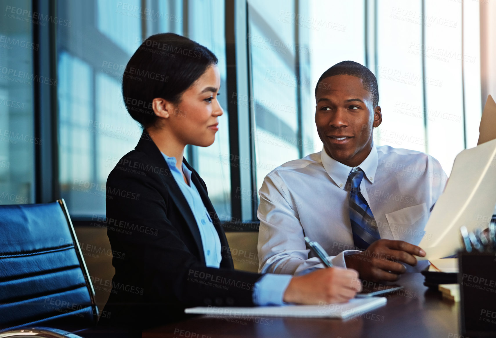 Buy stock photo Cropped shot of two young businesspeople meeting in the boardroom