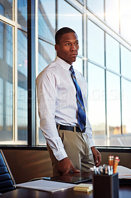 Buy stock photo Shot of a young male lawyer standing by his desk in the office