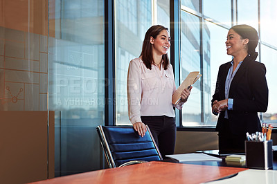 Buy stock photo Shot of two young lawyers having a conversation in their office