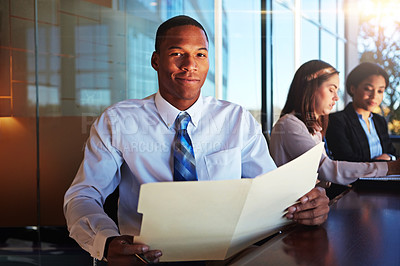 Buy stock photo Cropped portrait of a young businessman sitting in a meeting with her boardroom