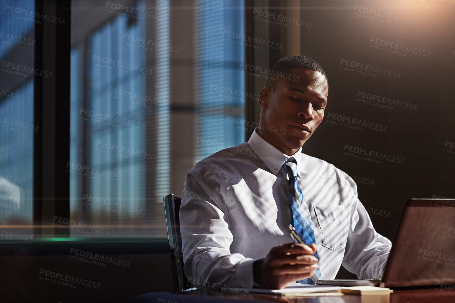 Buy stock photo Shot of a businessman using his laptop at his desk