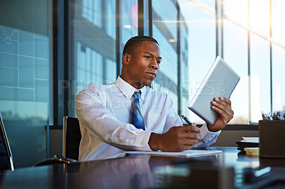 Buy stock photo Cropped shot of a businessman taking notes while using his tablet