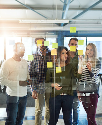 Buy stock photo Shot of colleagues having a brainstorming session with sticky notes at work