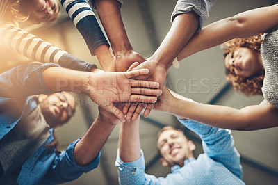 Buy stock photo Shot of a group of creative businesspeople standing with their hands in a huddle