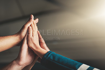 Buy stock photo Shot of a group of creative businesspeople high fiving one another in their office