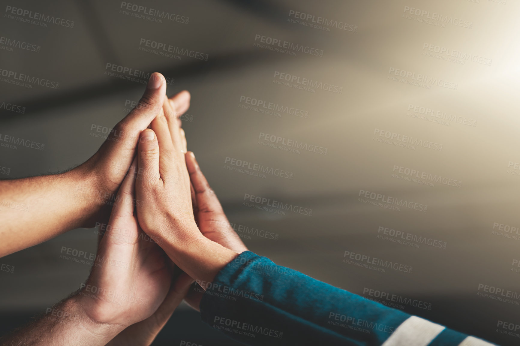 Buy stock photo Shot of a group of creative businesspeople high fiving one another in their office