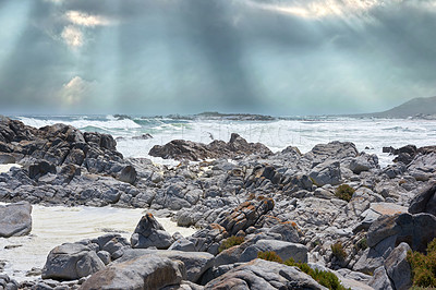 Buy stock photo Rocks, beach and ocean coast for travel, holiday or vacation in nature with clouds outdoor. Sea water, stones and waves in horizon with land for tourism, adventure island or environment in Australia