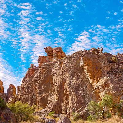 Buy stock photo Outcrop, erosion and sky with rock, formation and geology at location, bush and clouds in summer. Countryside, stone and landscape at nature park, field and mountain with sunshine in South Africa