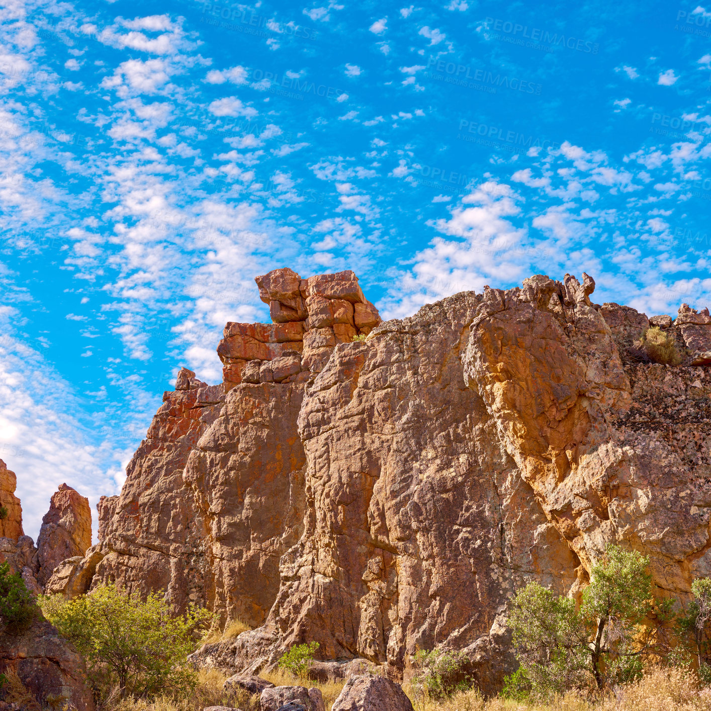 Buy stock photo Outcrop, erosion and sky with rock, formation and geology at location, bush and clouds in summer. Countryside, stone and landscape at nature park, field and mountain with sunshine in South Africa