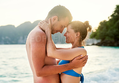 Buy stock photo Cropped shot of a young couple enjoying the day at the beach