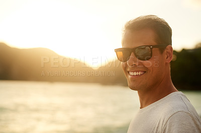 Buy stock photo Portrait of a handsome young man standing on the beach at sunset
