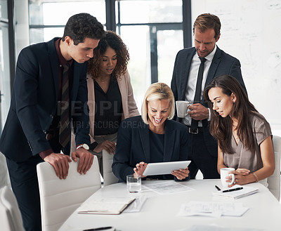 Buy stock photo Cropped shot of a group of businesspeople using a digital tablet during a meeting in an office