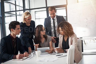 Buy stock photo Cropped shot of a group of businesspeople using a digital tablet during a meeting in an office