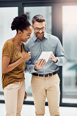 Buy stock photo Cropped shot of two businesspeople looking at a digital tablet in their office