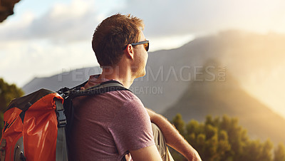 Buy stock photo Shot of a young man admiring the view from the top of a mountain