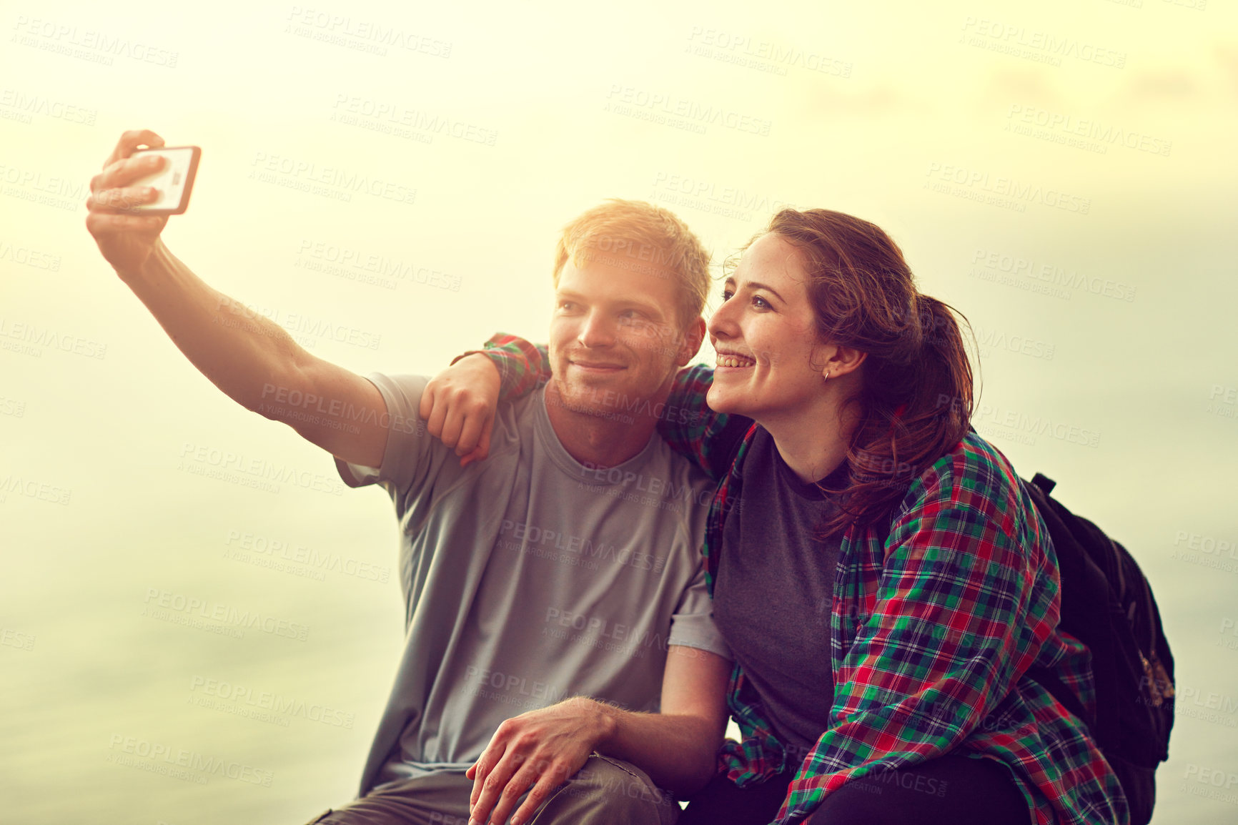 Buy stock photo Cropped shot of a young couple taking a selfie on a mountain top