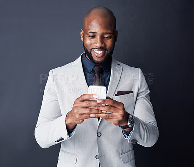 Buy stock photo Studio shot of a businessman using a mobile phone against a gray background