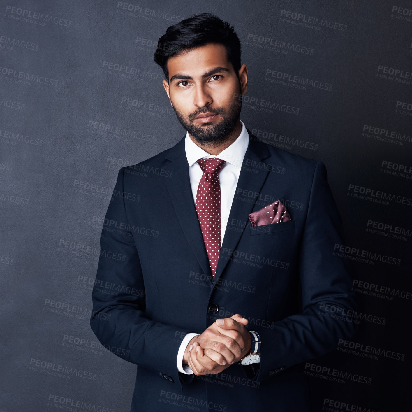 Buy stock photo Studio shot of a confident young businessman posing against a gray background
