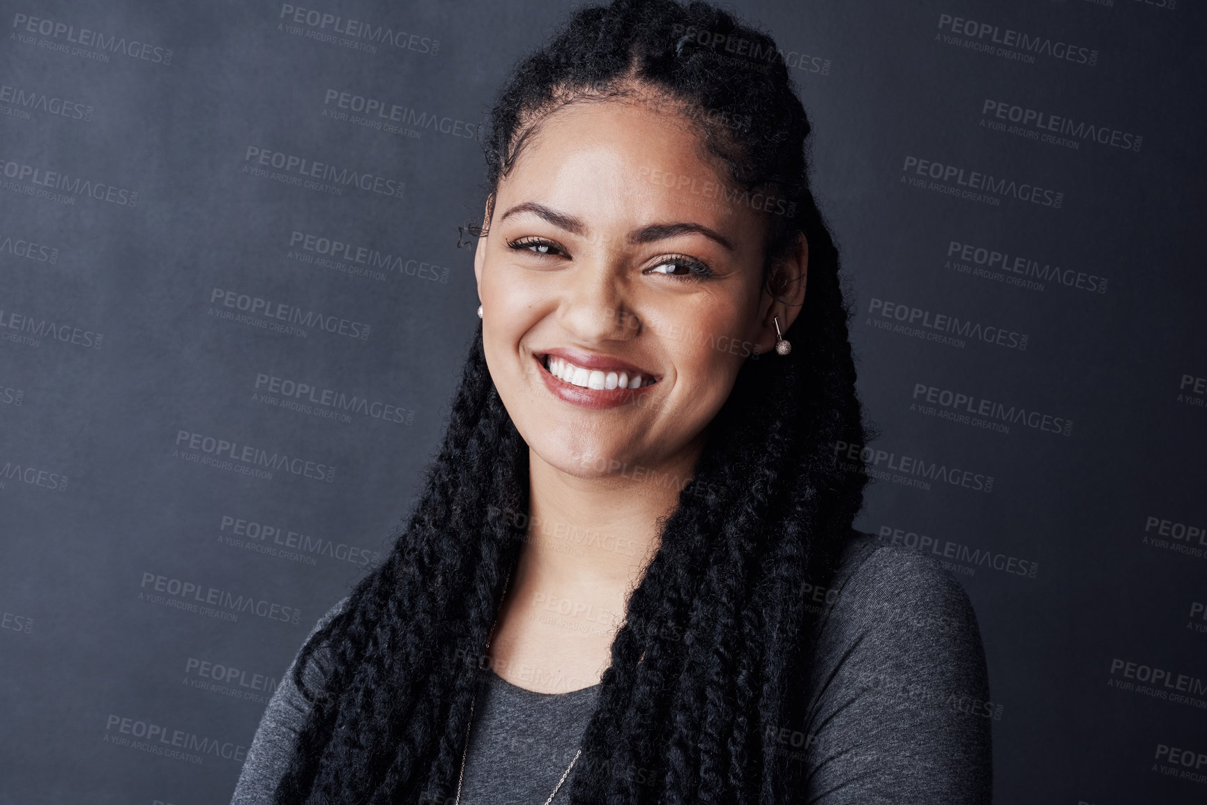 Buy stock photo Studio shot of a young woman posing against a gray background