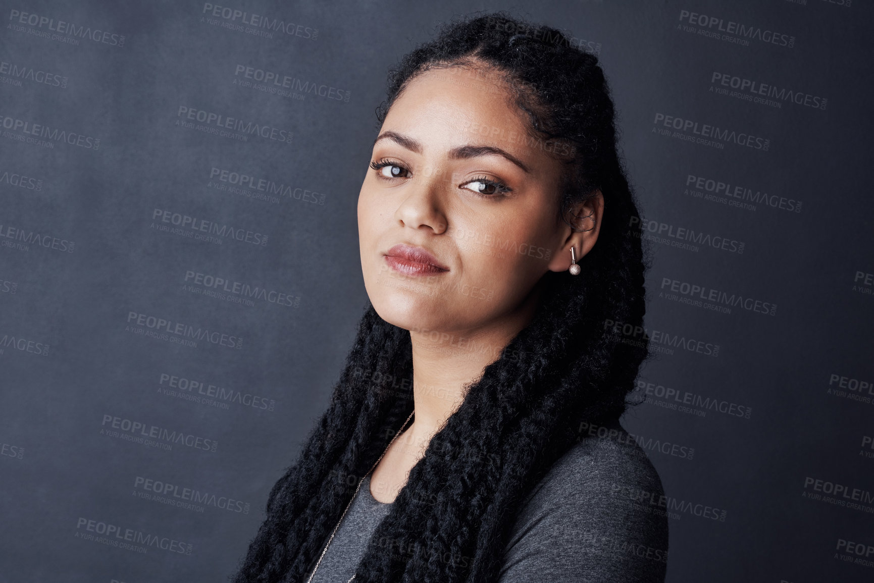 Buy stock photo Studio shot of a young woman posing against a gray background