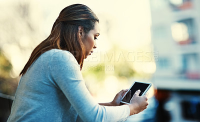 Buy stock photo Shot of a businesswoman using her tablet while standing outside on the balcony
