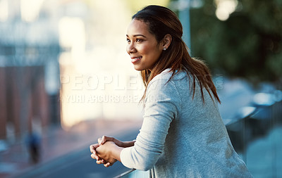 Buy stock photo Shot of an attractive young businesswoman standing on her office balcony