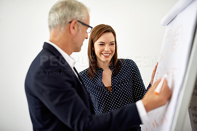 Buy stock photo Cropped shot of two colleagues brainstorming on a whiteboard in an office