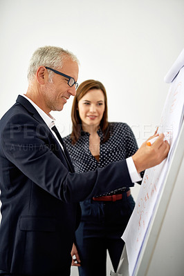 Buy stock photo Cropped shot of two colleagues brainstorming on a whiteboard in an office