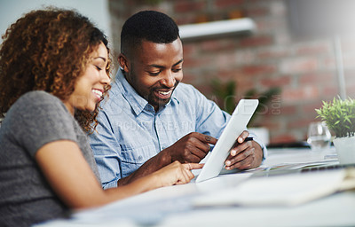 Buy stock photo Cropped shot of two colleagues using a digital tablet in an office