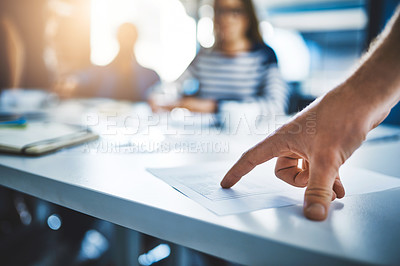 Buy stock photo Cropped shot of a businessperson pointing to a document during a meeting in an office