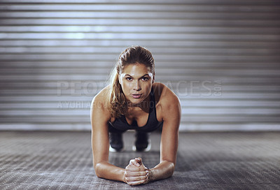 Buy stock photo Shot of a young woman doing push-ups at the gym