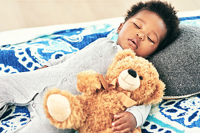 Buy stock photo Shot of a baby boy asleep with his teddy bear in his arm