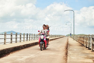 Buy stock photo Shot of a young couple enjoying a scooter ride