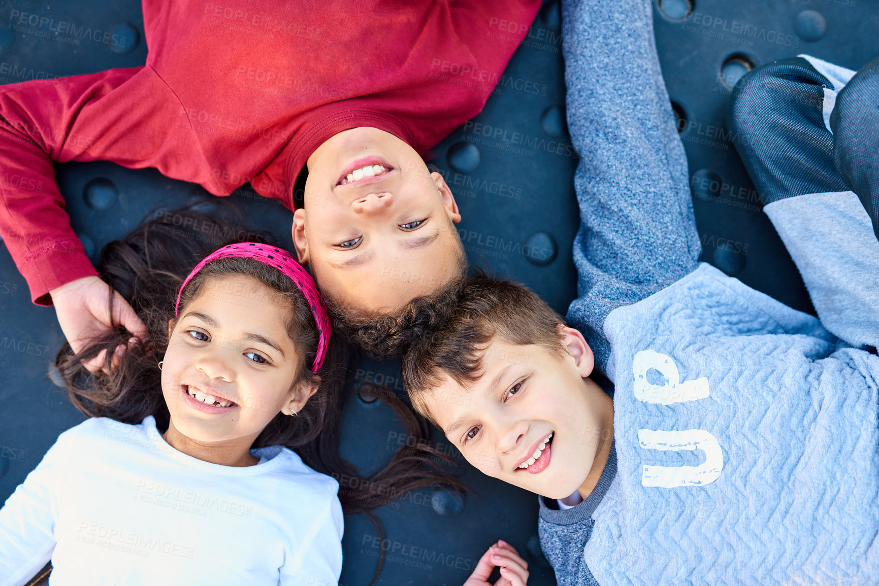 Buy stock photo Portrait of three young siblings playing together at the park