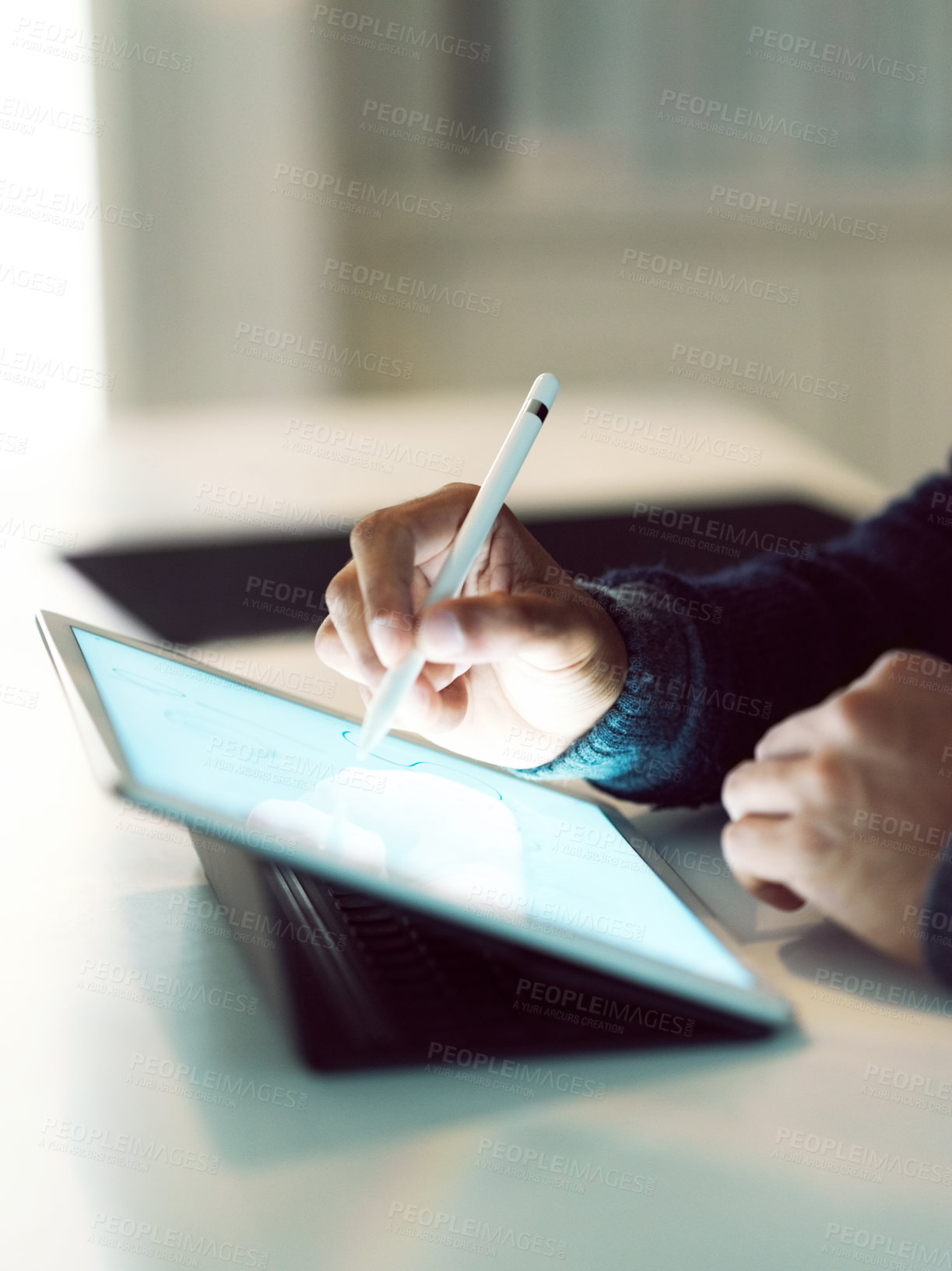 Buy stock photo Cropped closeup shot of an unrecognizable man sitting at a table using a digital tablet and pen