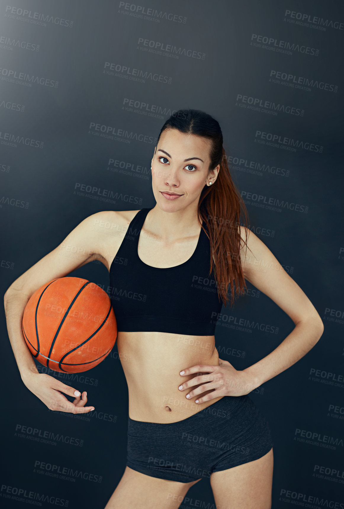 Buy stock photo Studio portrait of an attractive young woman holding a basketball
