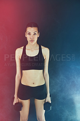 Buy stock photo Shot of a young woman working out with dumbbells