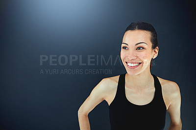 Buy stock photo Shot of a sporty young woman posing against a dark background